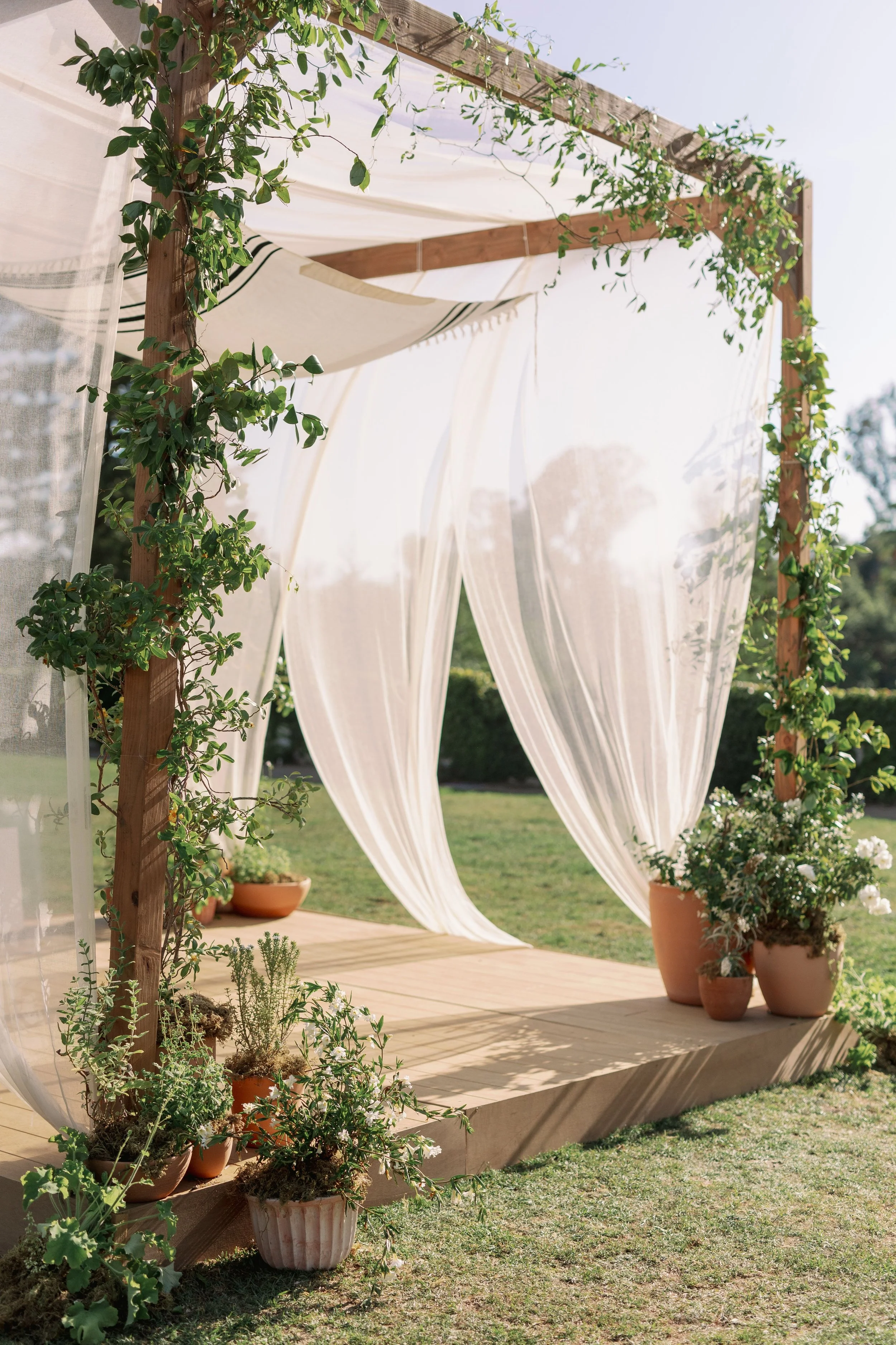 Ceremony arch with draped fabric and greenery