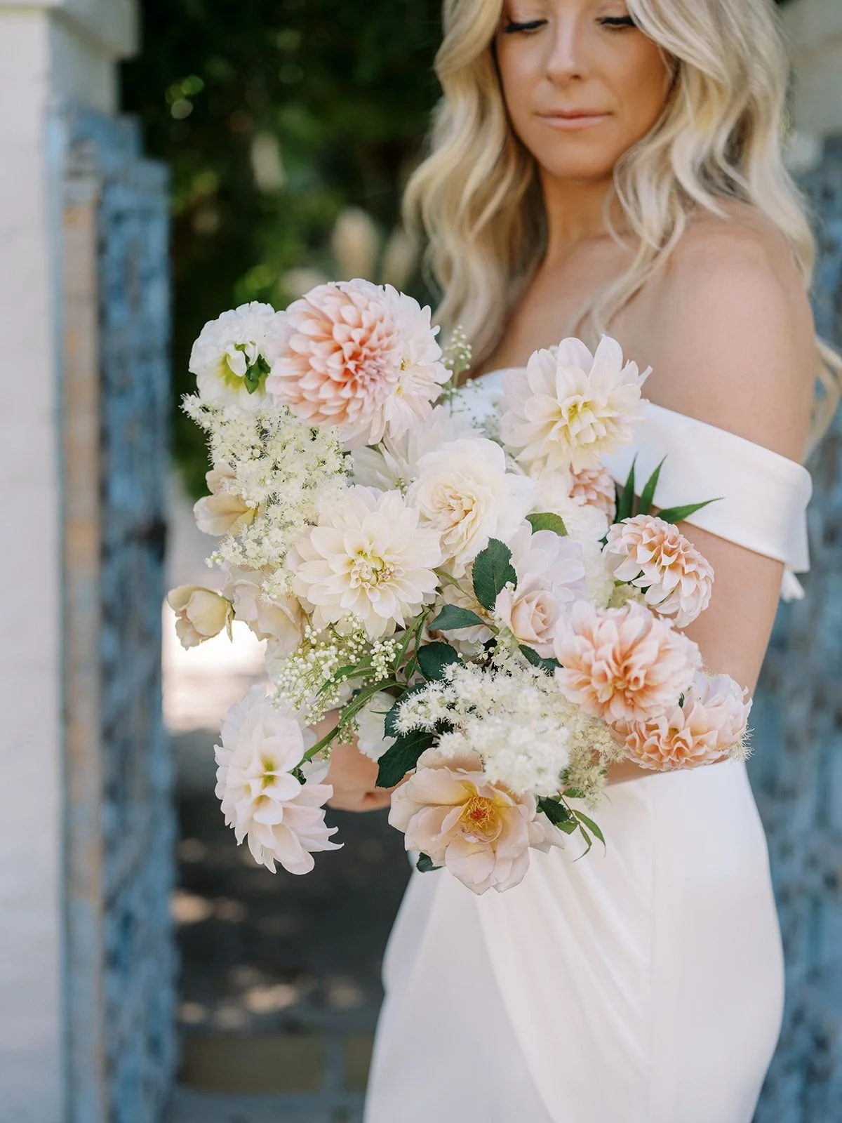Bride holding a soft blush and cream bridal bouquet